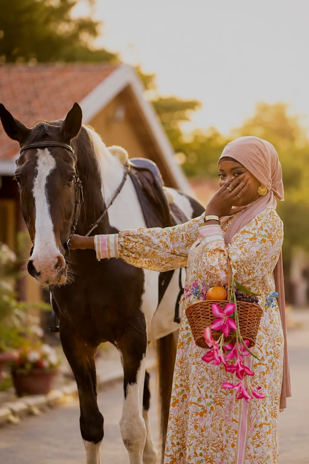 Une Bloomie riant, tout près d'un cheval, panier de fleurs au bras